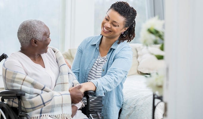 family caregiver helping elderly parent in chair