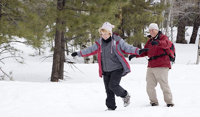 Active retired couple playing in the snow