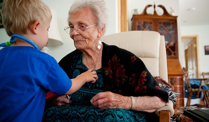 A 92 year old woman is playing doctor with a toddler