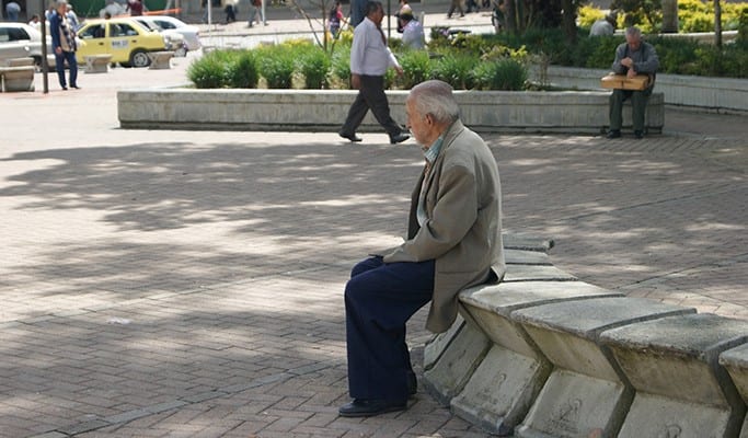 elderly man sitting on a bench outside