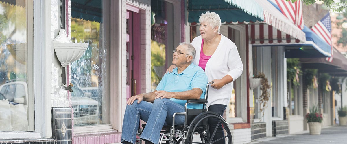 Senior couple window shopping, man in wheelchair
