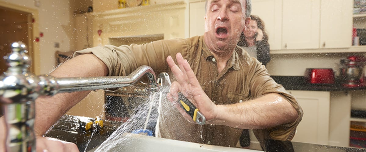 man tries DIY plumbing on a leaking faucet but gets wet