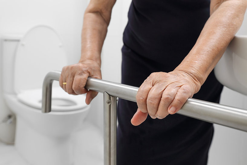 Senior holding on to handrail in the bathroom