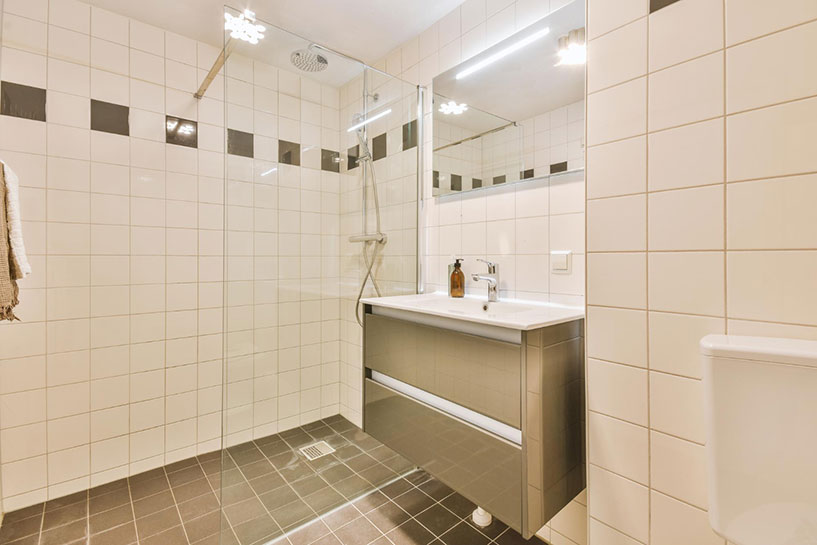 Shower stall with glass door next to bathroom sink