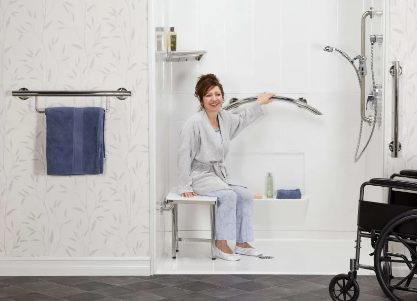 Women in handicapped accessible shower surrounded by grab bars - shower heads - and other shower accessories