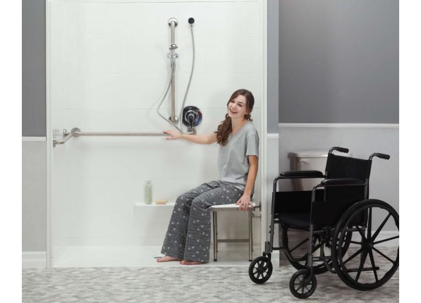 Women in an ADA roll in shower with wheelchair nearby