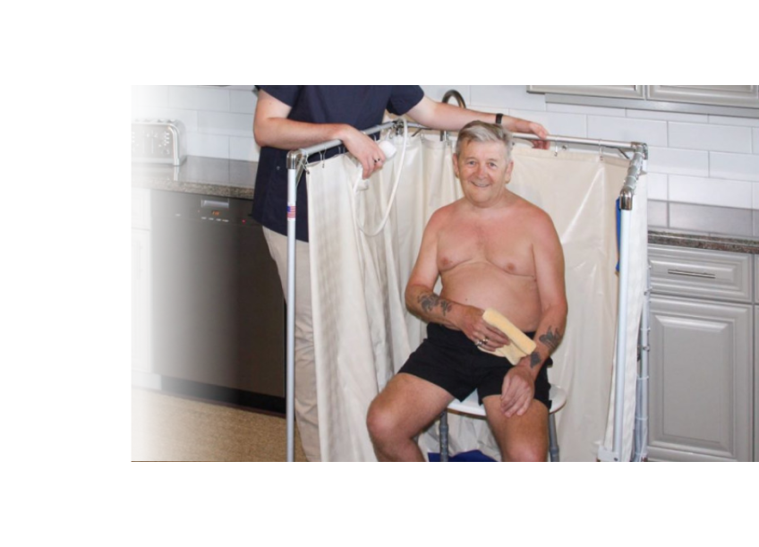 Man getting help showering in temporary Portable Indoor Showers that is accessible to wheelchairs
