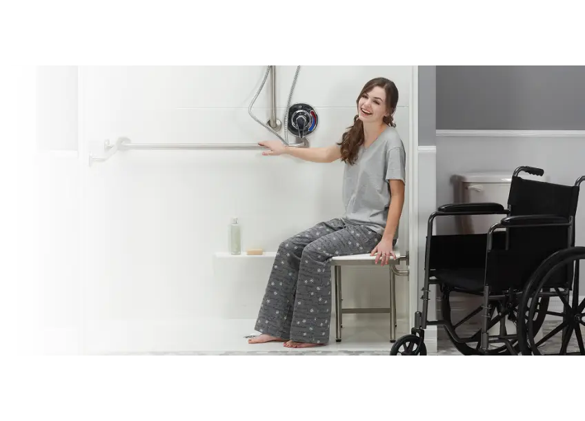 Women in an ADA roll in shower with wheelchair nearby