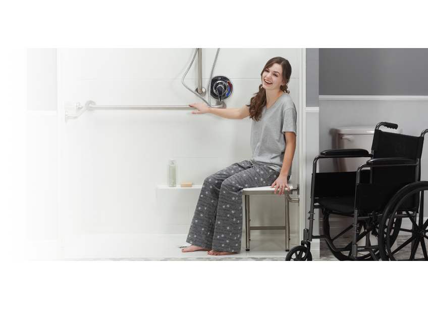 Women in an ADA roll in shower with wheelchair nearby