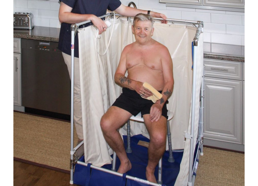 Man getting help showering in temporary Portable Indoor Showers that is accessible to wheelchairs