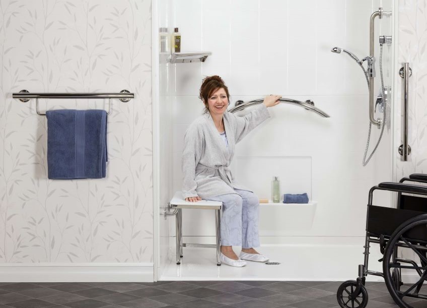 Women in handicapped accessible shower surrounded by grab bars - shower heads - and other shower accessories