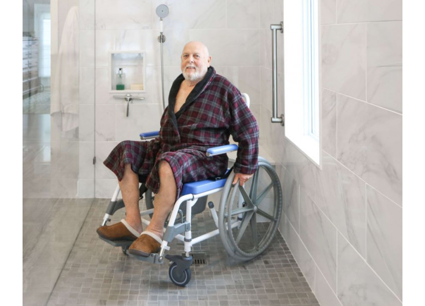 man in rolling shower chair for handicapped access